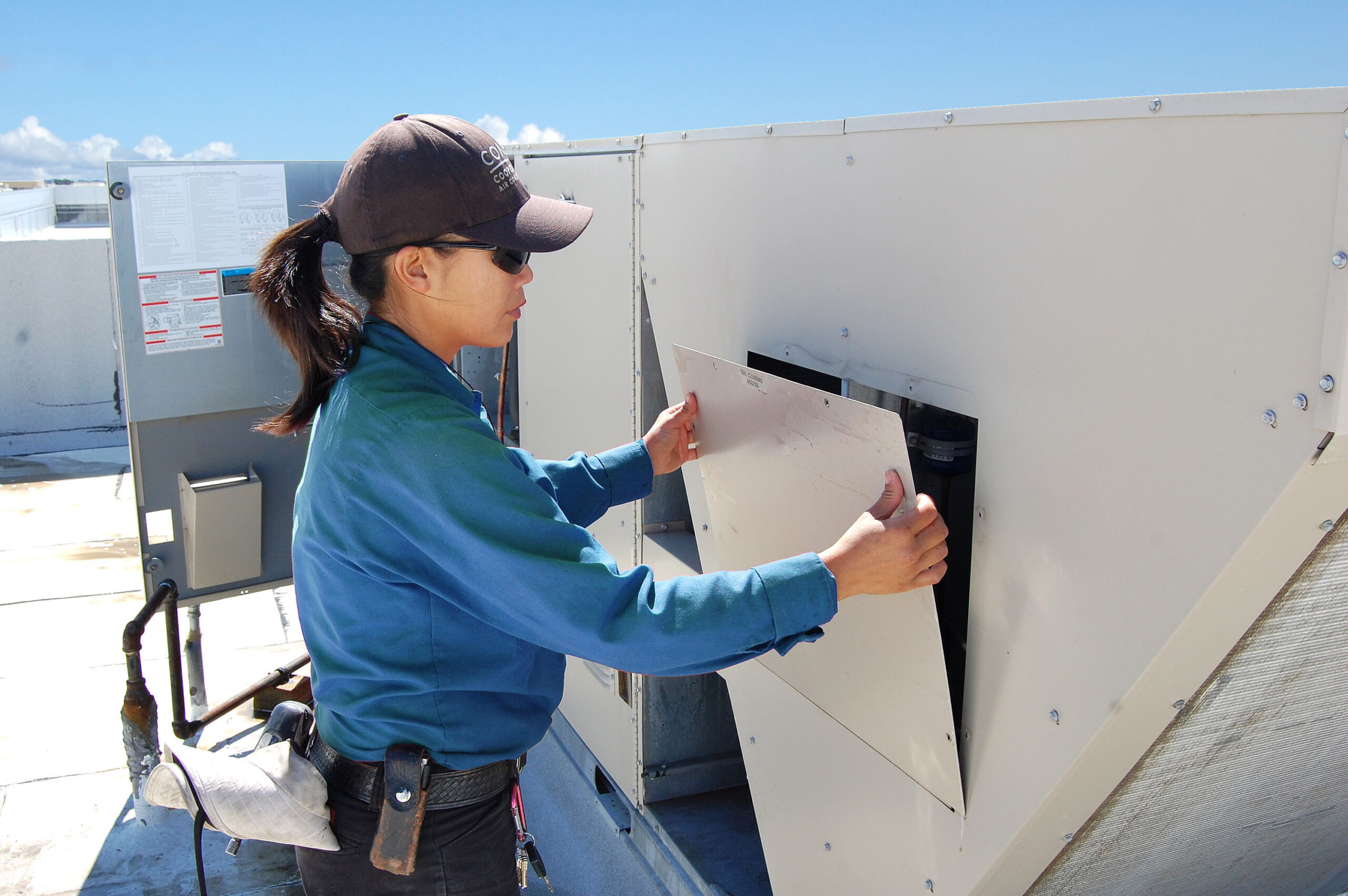 HVAC tech removing rooftop unit panel