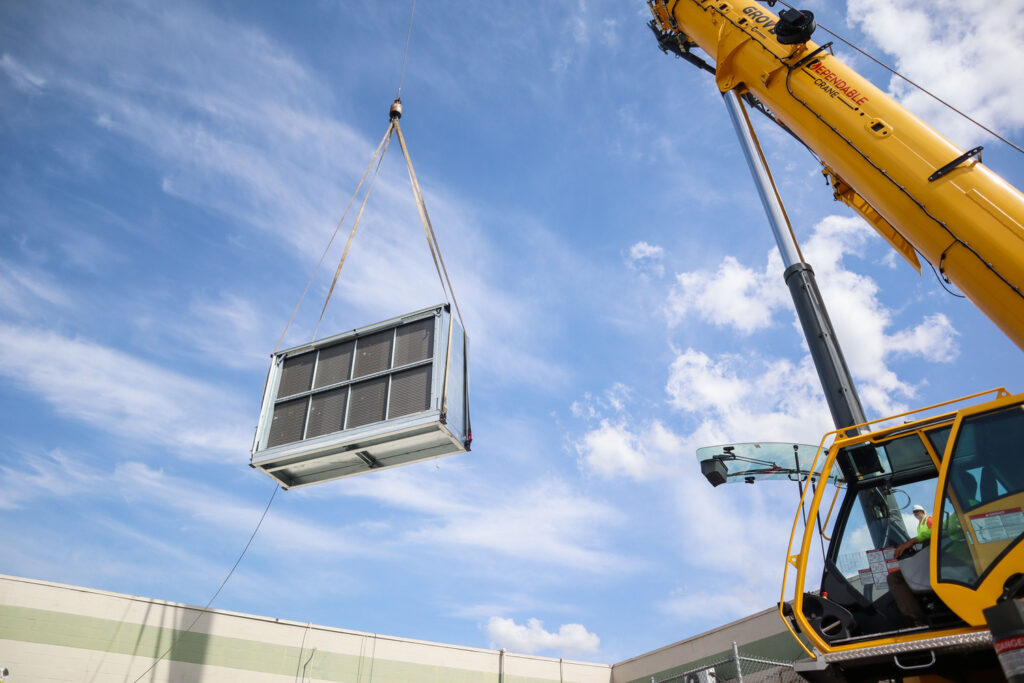 Air handler being lifted by crane