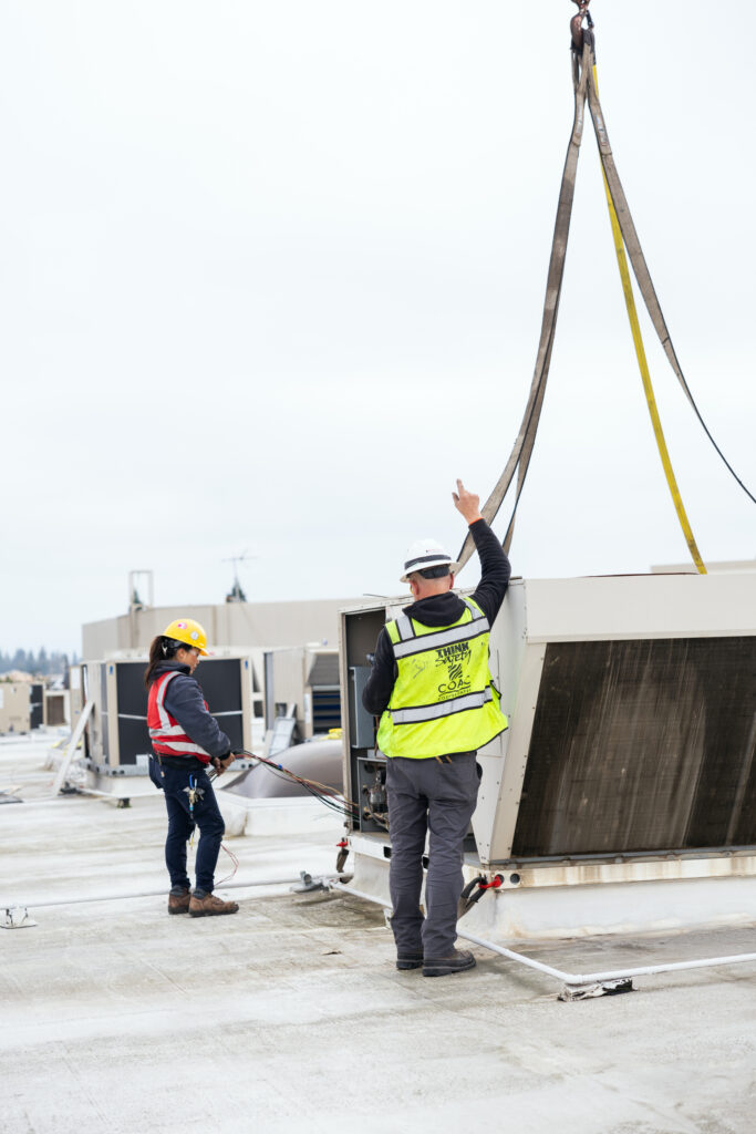Man on roof signaling crane