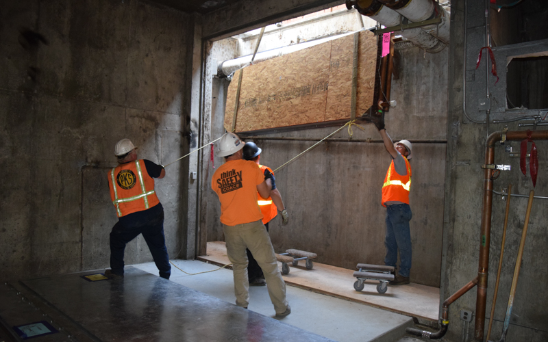 HVAC equipment being lowered into building